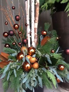 a vase filled with christmas decorations and greenery