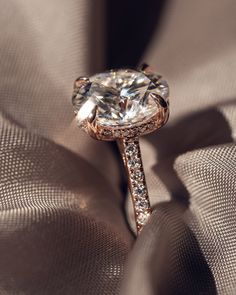 a diamond ring on top of a satin material