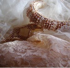 two bracelets sitting on top of a piece of lace next to each other,