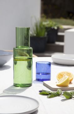 a table topped with plates and glasses next to a slice of lemon on top of a cutting board