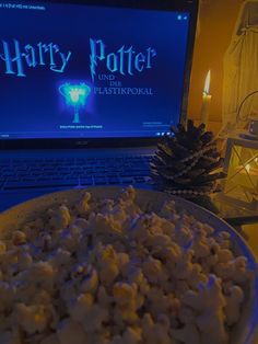 a bowl of popcorn sitting in front of a laptop