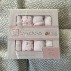 a package of baby swaddles with pink and white designs on the packaging side