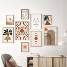 a white room with many framed pictures on the wall and a chair in front of it