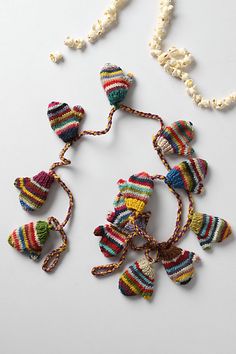 multicolored beaded necklace on white surface with beads and pearls hanging from it