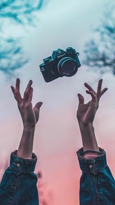 two hands reaching up towards a camera in the sky