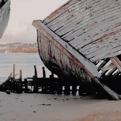 an old wooden boat sitting on top of a beach