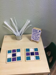 a wooden table topped with blue and white mosaic tiles next to a potted plant