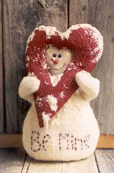 a snowman holding a heart with the word mom written on it