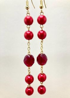 Ruby Red Pearl Bead Acrylic Bead Dangle Drop Earrings w Gold Tone Accents. 3.50 in. drop. Red Beaded Earrings For Holiday With Round Beads, Red Faceted Beads Earrings For Festive Occasions, Red Beaded Earrings For Holiday, Holiday Red Beaded Earrings With Ear Wire, Party Large Beaded Drop Earrings, Red Dangle Beaded Earrings For Party, Red Chandelier Earrings With Dangling Beads As Gift, Red Beaded Chandelier Earrings For Party, Gift Red Chandelier Earrings With Dangling Beads