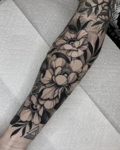 a black and white flower tattoo on the arm