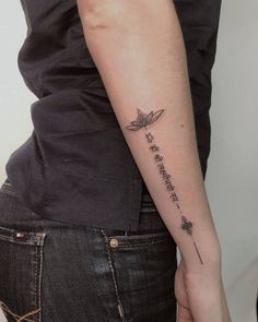 a woman with a tattoo on her arm that says, be yourself and the leaves are flying