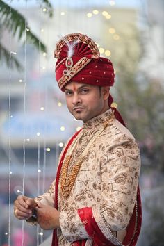 a man in a red turban and gold outfit