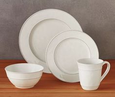 white dishes and cups sitting on top of a wooden table