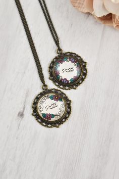 two necklaces that are sitting on top of a table