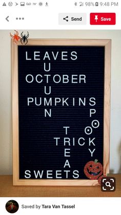 a sign that is on top of a wooden table next to a pumpkin and spider webcam