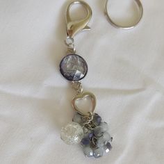 a keychain with charms attached to it on a white cloth covered tablecloth