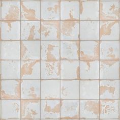 a white and tan tiled wall with some brown spots on it's surface,