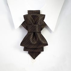 "Filled with a light metallic luster, bow tie \"Copper\" is an accessory with subtle luxury. Two pleats give Copper glamor, and we suggest it with combinations of dark brown and black suits and light shirts. This unisex accessory is a modern combination of elements found on traditional ties and bow ties. It is recommended not to tighten the regulation strip too much: Tie is at its best when leveled up with the collar line. Freestyle fashion lovers should bear in mind that this accessory also loo Elegant Formal Ties For Father's Day, Elegant Ties For Black Tie Events And Father's Day, Formal Gold Suit And Tie Accessories With Decorative Bow, Elegant Black Tie For Father's Day, Elegant Gold Bow With Ties, Gold Bow Ties For Black Tie Events, Brown Ties For Business And Father's Day, Classic Gold Bow Tie For Business, Brown Business Ties For Father's Day