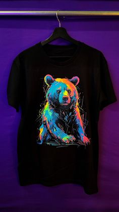 "Introducing the \"Beaming Bear: Exclusive Glow T-shirt\"  - a delightful addition to your wardrobe that will brighten your day with adorable charm! This captivating t-shirt showcases a cute and colorful bear design, perfect for those who adore bears and appreciate a splash of vibrant hues. 🎨 Captivating Prints: Our skilled artists have crafted an enchanting and lively bear print, ensuring that each shirt is a unique and exclusive piece of wearable art. 💡 Glow Under UV Light & In the Dark: Infuse your style with a touch of magic through the mesmerizing glowing features of this t-shirt. When exposed to UV light, the bear design illuminates with radiant colors, emanating a captivating glow that is sure to draw attention. Additionally, the design also glows in the dark, making it a delightf Kids Painting Projects, Art Glow, Bear T Shirt, Bear Design, Bear Print, Uv Light, Brighten Your Day, In The Dark, Wearable Art