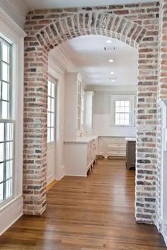 an empty room with wood floors and brick walls