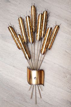 a clock made out of gold sticks on top of a wooden table