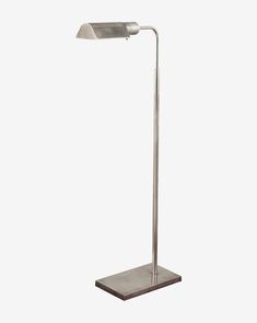 a floor lamp with a metal base and a white light on the top of it