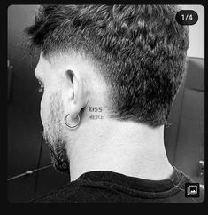 the back of a man's head with tattoos on his neck and behind him is a mirror