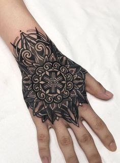 a person's hand with a tattoo on it and a flower in the middle