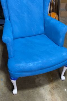 a blue chair sitting on top of a cement floor