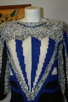 "Super cool sweater with subdued sparkly detail from the 80s by Jason Maxwell. Unique sweater in blue, white, black and grey. It gives me mad art deco vibes. Fabulous pullover sweater has blue sequin with a small seed bead in each sequin around the neck. The front features a silvery sequin also with beads. The back of the 3/4 sleeves features a different colorway from the front. Jason Maxwell 100 % Acrylic Machine Wash Separately Warm Tumble or Line Dry Made in Taiwan Tag reads size Small, but a Blue Retro Sweater With Graphic Print, Retro Blue Knit Sweater, Vintage Blue Knit Sweater, Blue Retro Knit Sweater, 80s Skirts, Cool Sweater, White Art Deco, Blue And White Art, Unique Sweater