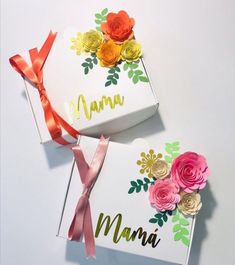 two gift boxes with flowers on them and the word mama written in gold foil