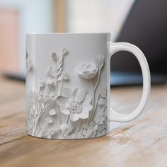 a white coffee mug sitting on top of a wooden table