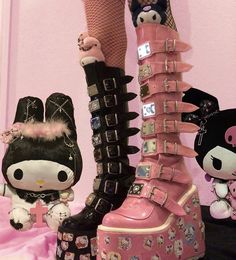 two stuffed animals are standing next to some boots with spikes on them and one is wearing high heeled shoes