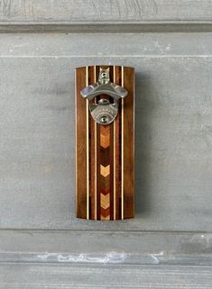 "Bottle opener with magnetic cap catcher.  The opener has five magnets embedded in the base.  One large magnet catches the caps after the bottle has been opened allowing for one handed bottle opening.    The opener is approximately 9\" long and 3.5\" wide.  Walnut/Maple/Zircote/Mahogany/Multi-Species Chevron There are four smaller magnets, one in each corner that will hold the opener to any ferrous metal surface like a painted steel refrigerator.   The opener can also be mounted to the wall or b Wood Bottle Opener, Magnetic Bottle Opener, Mounted Bottle Opener, Wall Mounted Bottle Opener, Wooden Pumpkins, Small Magnets, Bottle Opener, Craft Fairs, Wood Diy