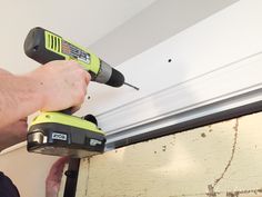 a man is using a drill to fix a hole in the ceiling