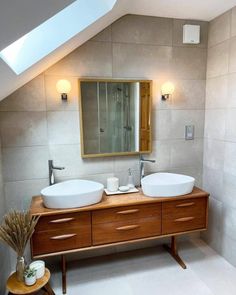 a bathroom with two sinks and a large mirror on the wall next to each other