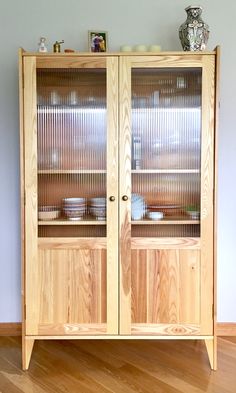 a wooden cabinet with glass doors on top