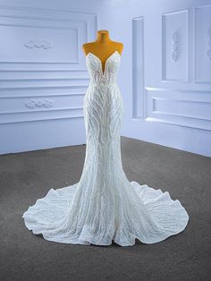 a white wedding dress on display in a room