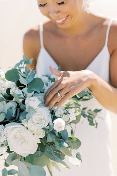 a woman holding a bouquet of white flowers