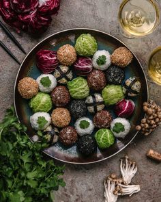 a plate full of different types of food next to some wine glasses and other items