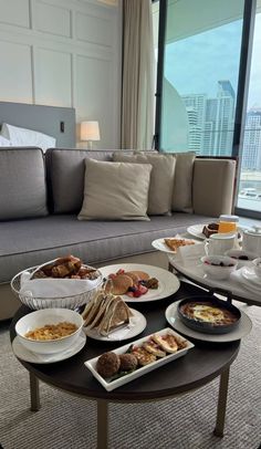 a living room filled with lots of food on top of a coffee table next to a couch