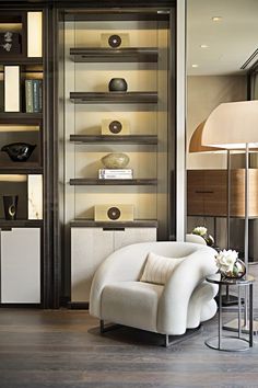 a white chair sitting in front of a book shelf