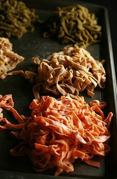 several different types of food are on a baking sheet, including noodles and carrots