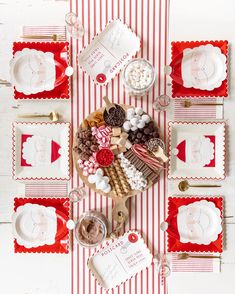 a table set with red and white striped placemats, candy bar trays, and plates