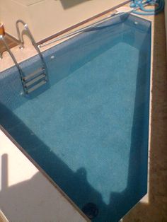 an empty swimming pool with ladders to the side and water coming out from it