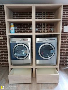 two washers are sitting in front of a brick wall with shelves on each side