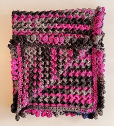 a crocheted square with pink and gray flowers