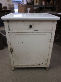 an old white cabinet sitting on the floor