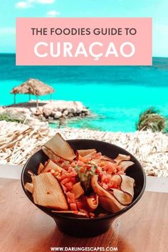 a bowl filled with food sitting on top of a wooden table next to the ocean