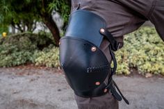 This listing is for a pair of leather Knee leg armor (Poleyn). They are constructed much like the elbow armor that I offer, but are obviously larger, and have panels and straps for above and below the knee so keep them securely in place. They are made from 8-10 oz Latigo cowhide, or vegetable tanned leather for the less standard colors. They have the option of having a second layer stitched over the bottom layer to add thickness, and also can be impregnated with wax to add rigidity to function a Leather Leg Armor, Elbow Armor, Knee Armor, Leg Armor, Character Clothing, Clothes Reference, Belt Holster, Leather Armor, Leather Cuts